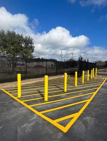 Fresh yellow bollards and striping on a commercial parking lot