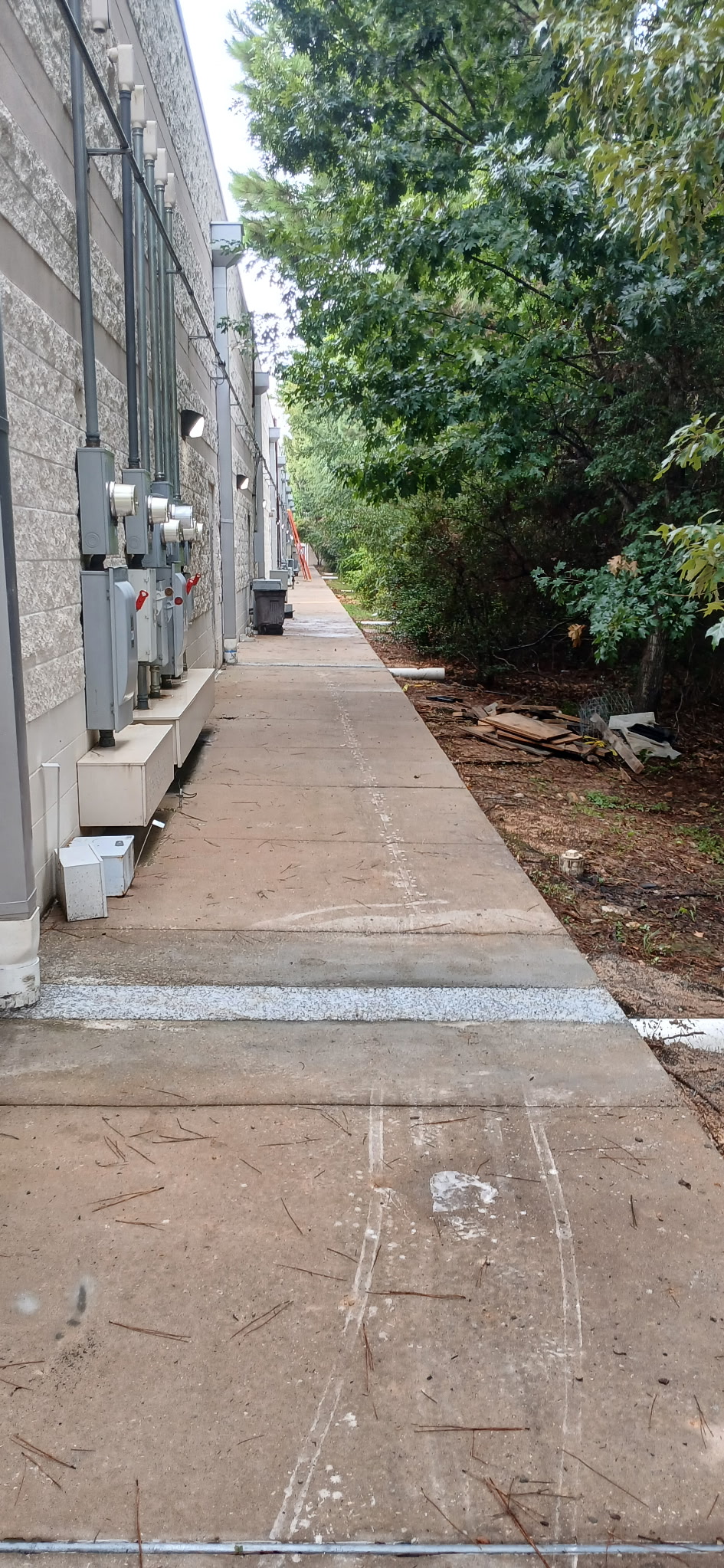 Restored service corridor walkway after a storm drain tie-in, dry concrete with no standing water