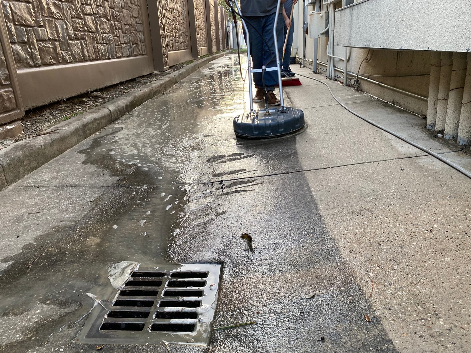 Technician pressure washing commercial building exterior